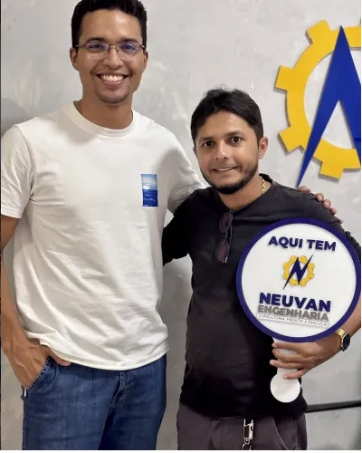 Cliente atendido pela Neuvan Engenharia segurando a placa da empresa
